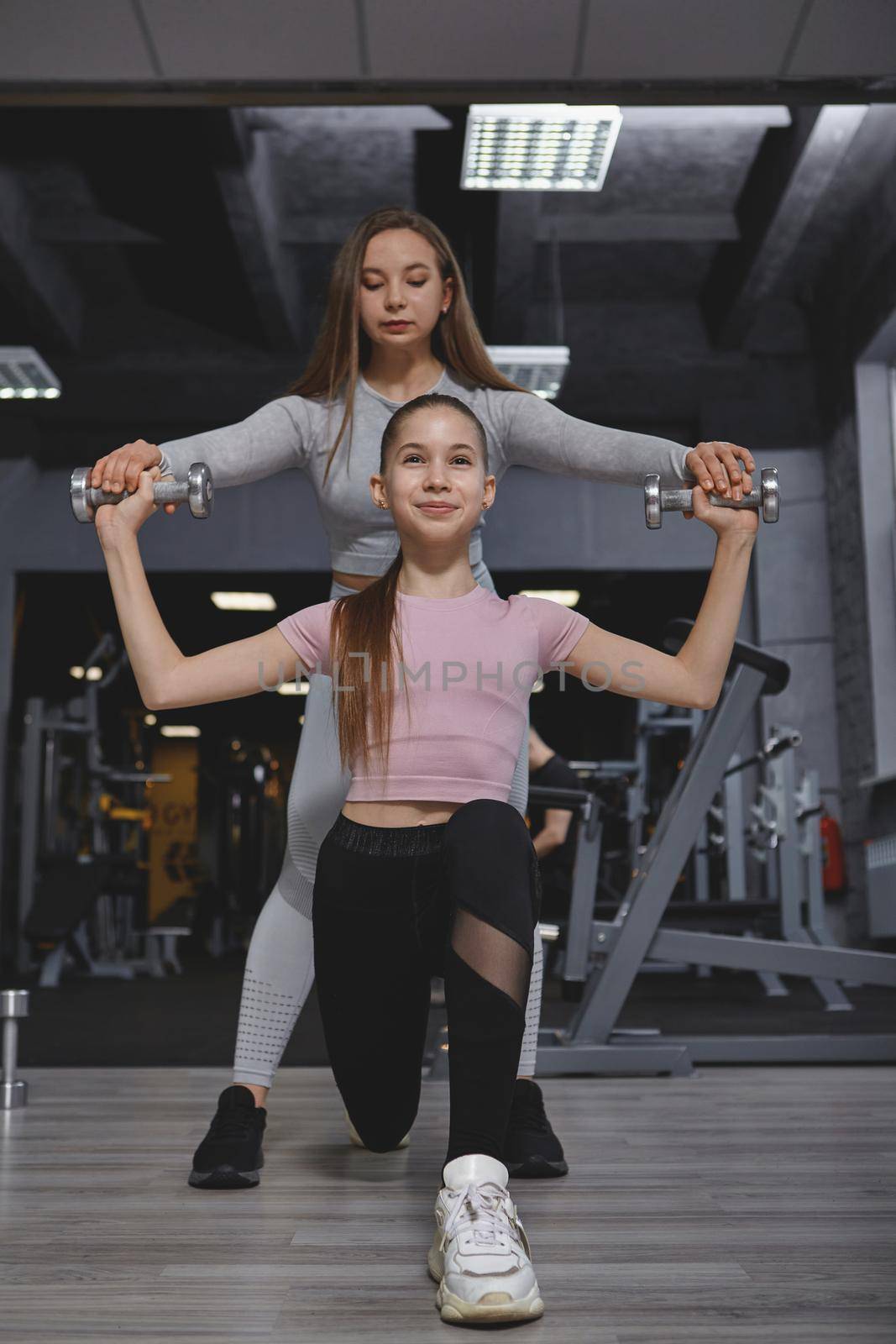 Teen Girl Exercising with Personal Trainer by MAD_Production