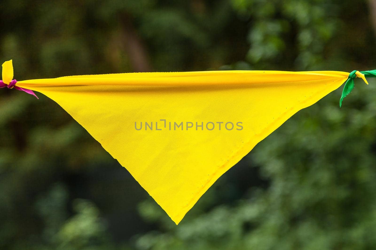 Yellow flag from a garland in the park.