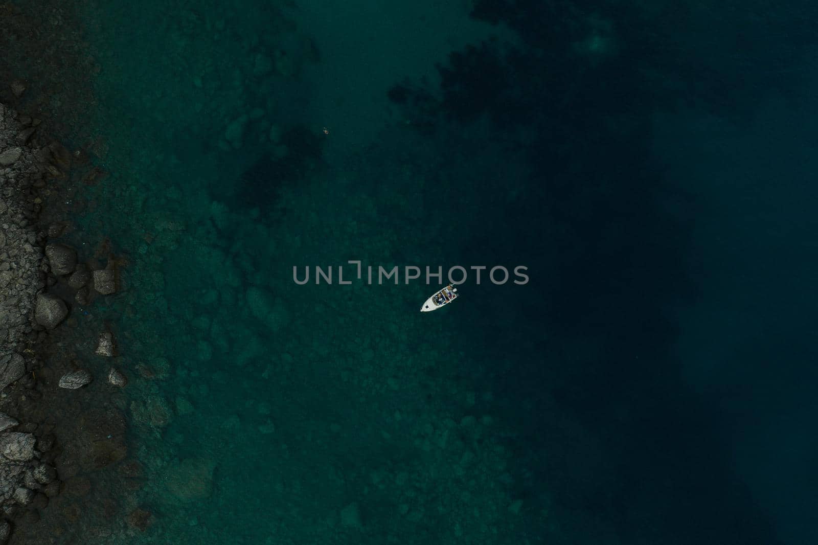 Aerial top nature view drone above yacht ship turquoise Adriatic sea in Albania. panoramic view marine. summer wallpaper. dark calm water rock bottom. mountain coast seaside. texture pattern mockup