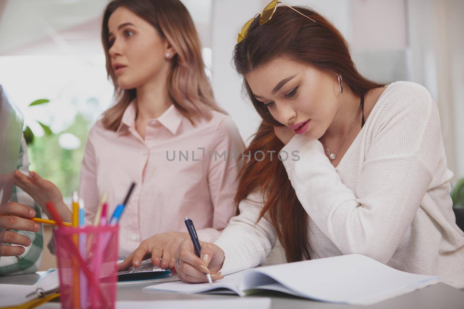 Female students working on a project together by MAD_Production