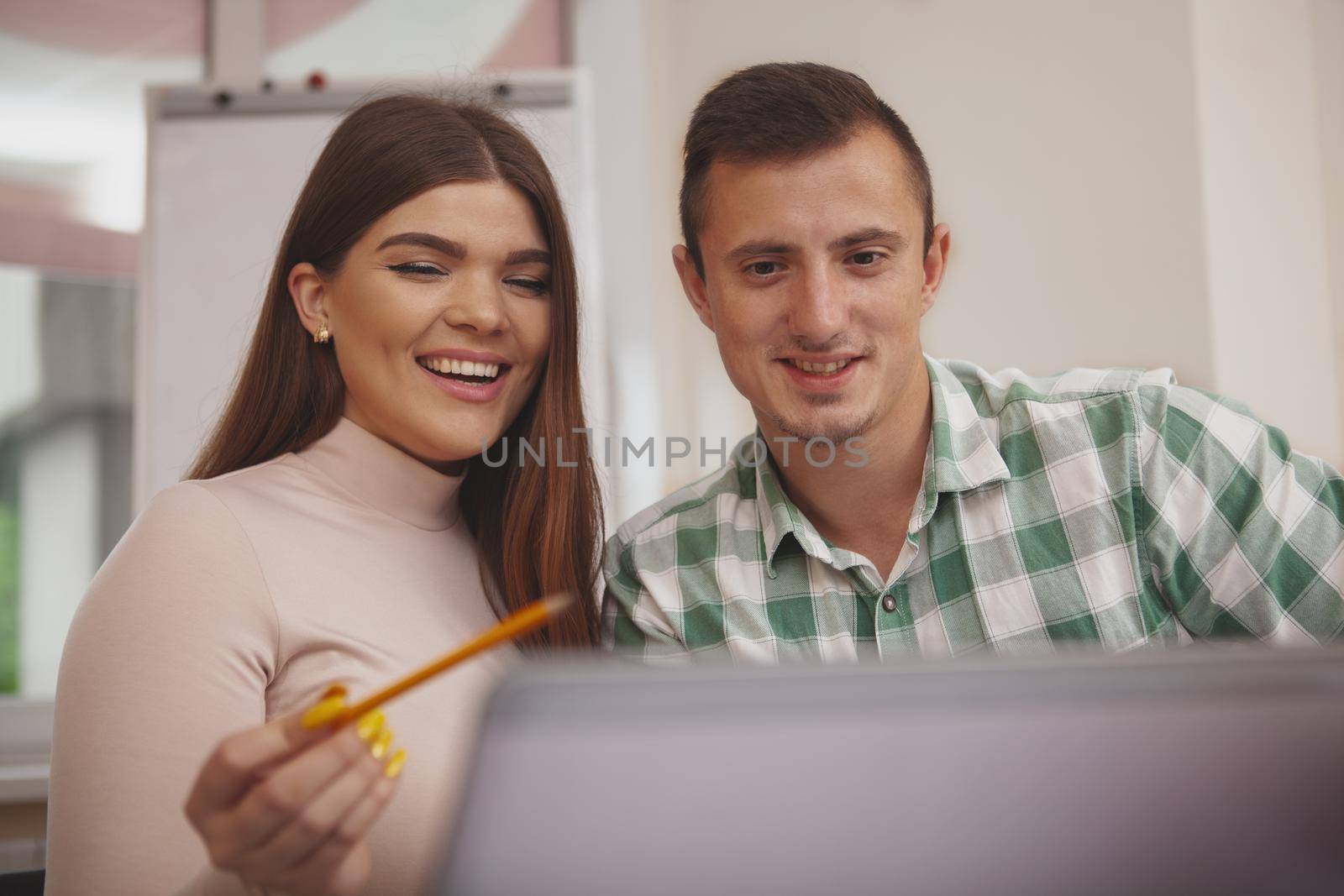 Friends, college lifestyle concept. Happy beautiful young woman laughing joyfully, studying online with her boyfriend. Cheerful students browsing online, preparing for exams