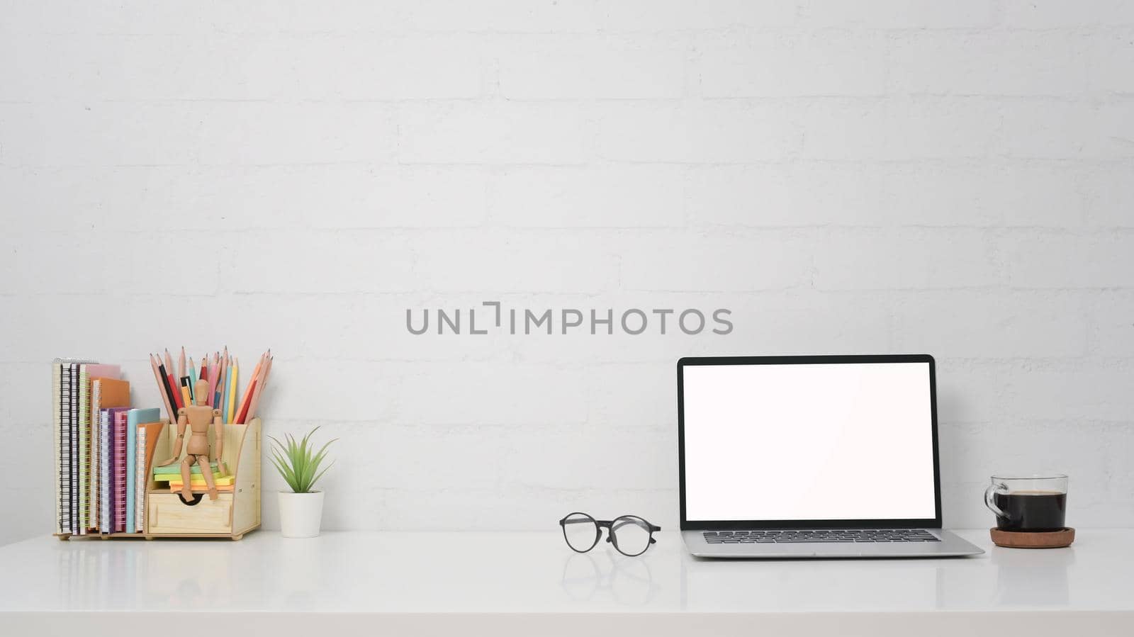 Computer laptop, coffee cup, glasses and stationery on white table. by prathanchorruangsak