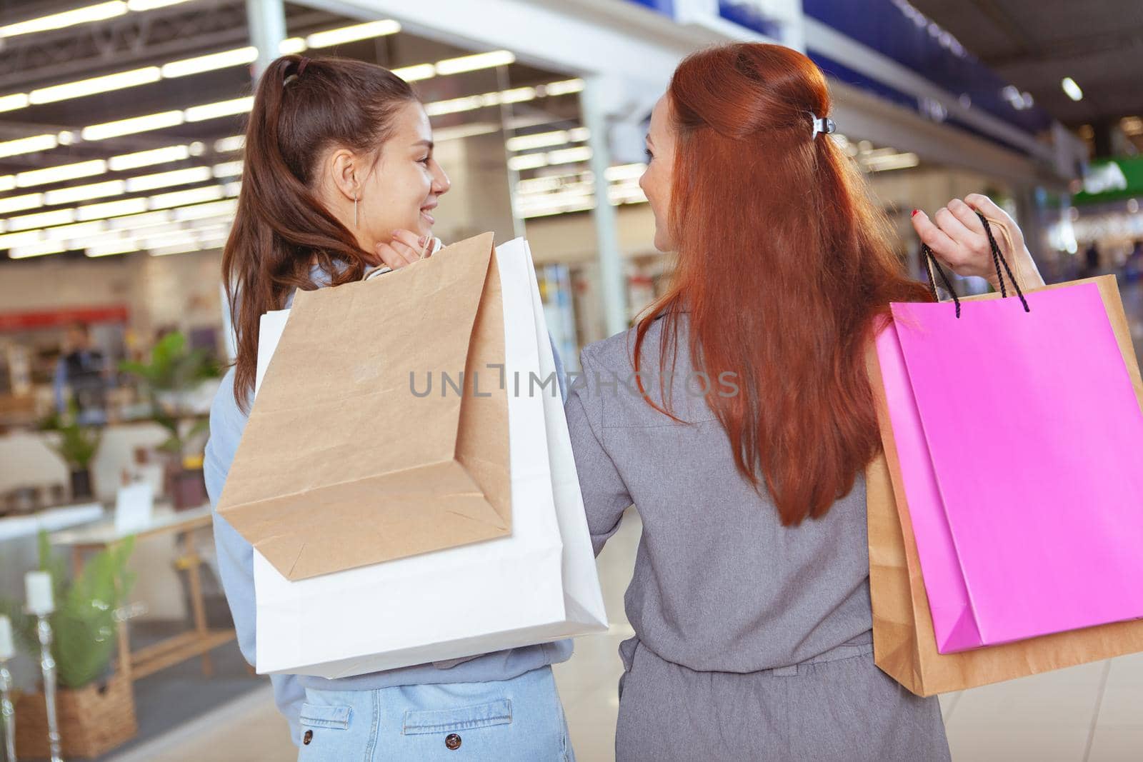 Female friends enjoying shopping together at the mall by MAD_Production