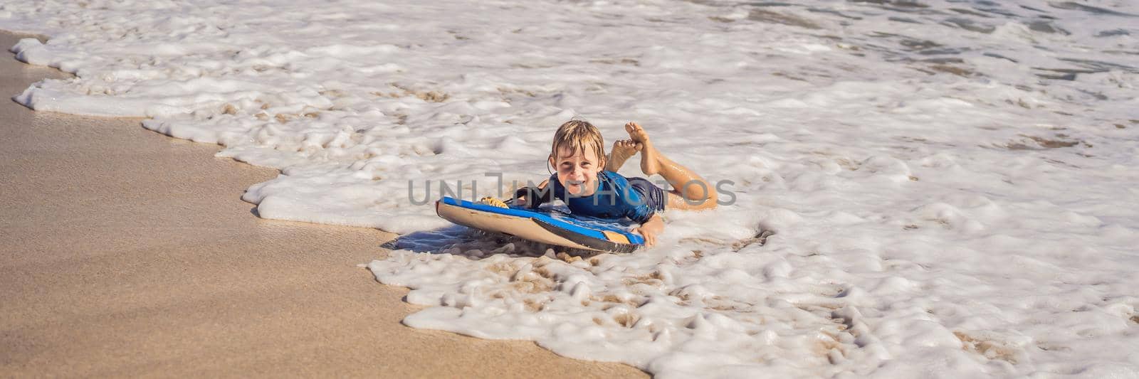 Happy Young boy having fun at the beach on vacation, with Boogie board BANNER, LONG FORMAT by galitskaya