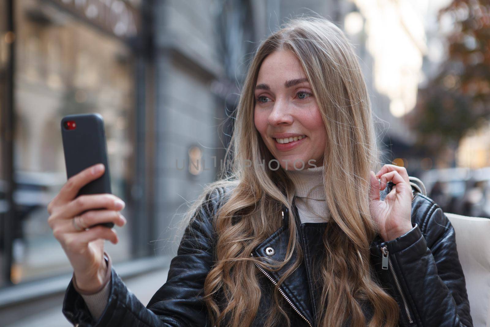 Close up of a woman taking a selfie with her smart phone outdoors