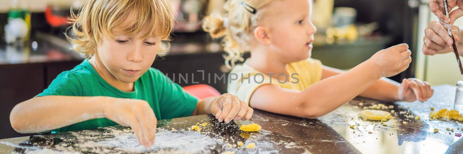 Two children a boy and a girl make cookies from dough. BANNER, LONG FORMAT