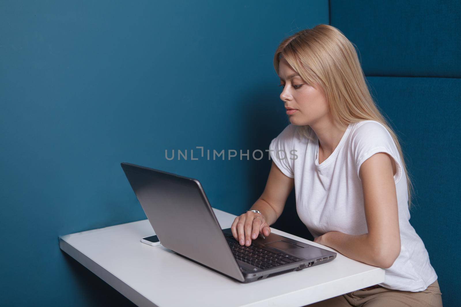 Attractive woman using her laptop, sitting in a modern workspace office