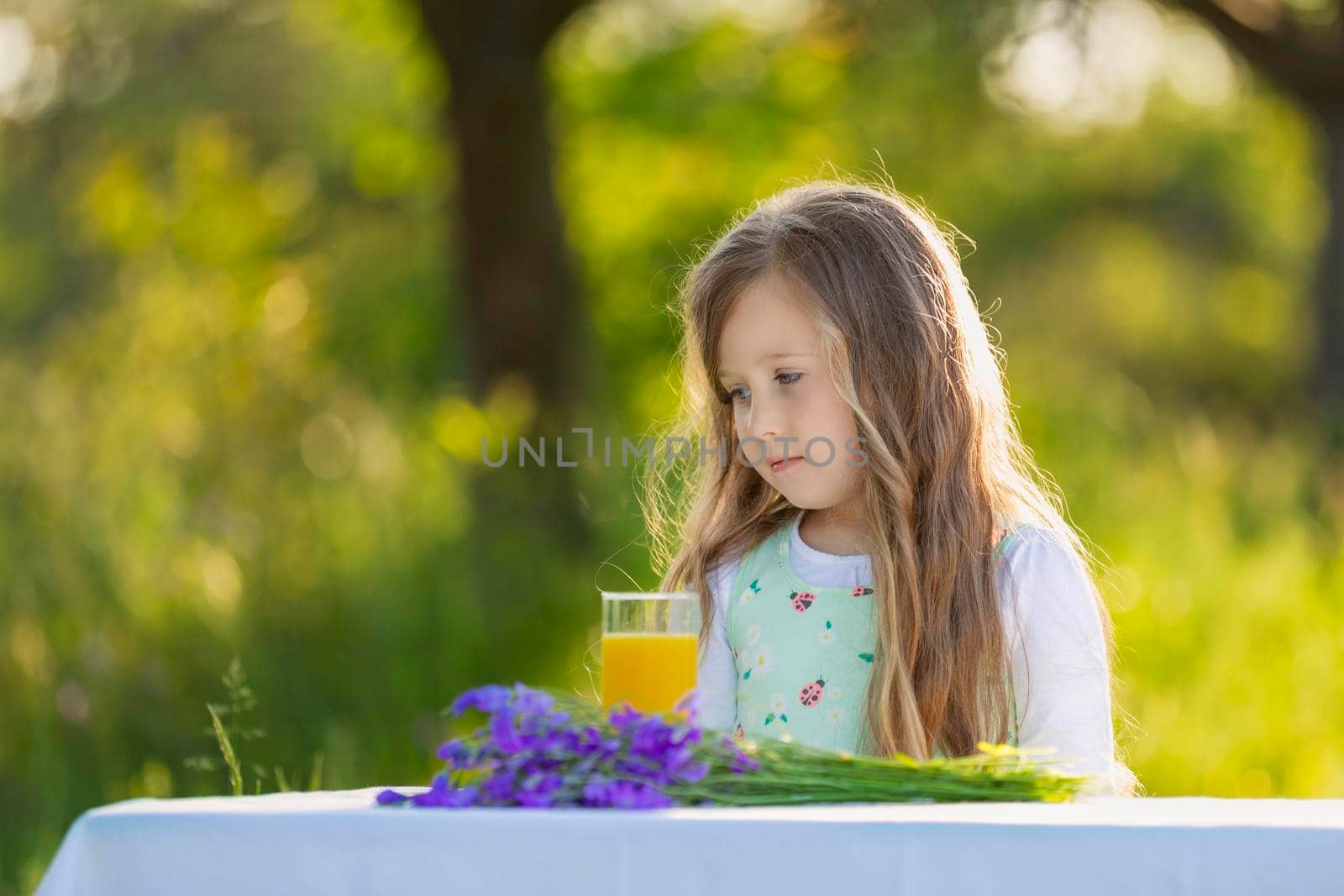 girl with a glass of orange juice in nature