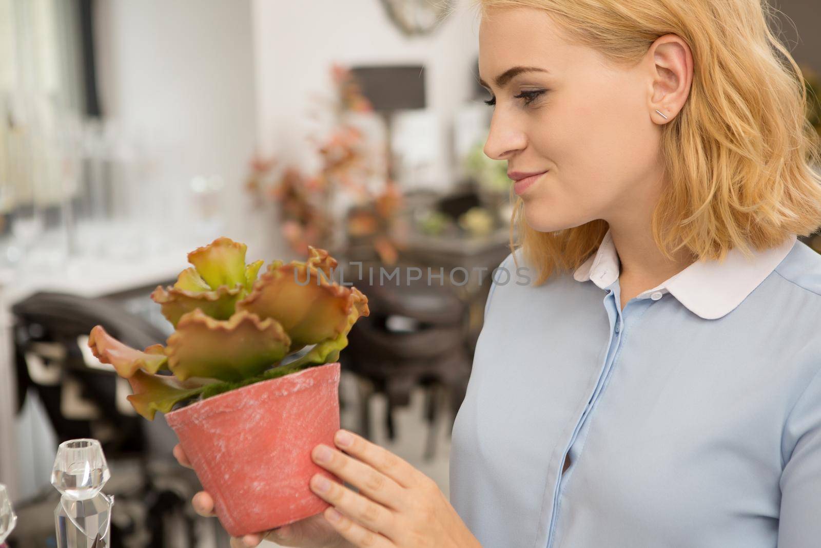 Cropped shot of a beautiful happy woman smiling holding a plant in a pot shopping at the greenhouse homeware store gardening natural planting positivity harmony happiness enjoyment retail sale