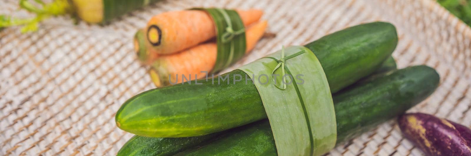 BANNER, LONG FORMAT Eco-friendly product packaging concept. Vegetables wrapped in a banana leaf, as an alternative to a plastic bag. Zero waste concept. Alternative packaging.