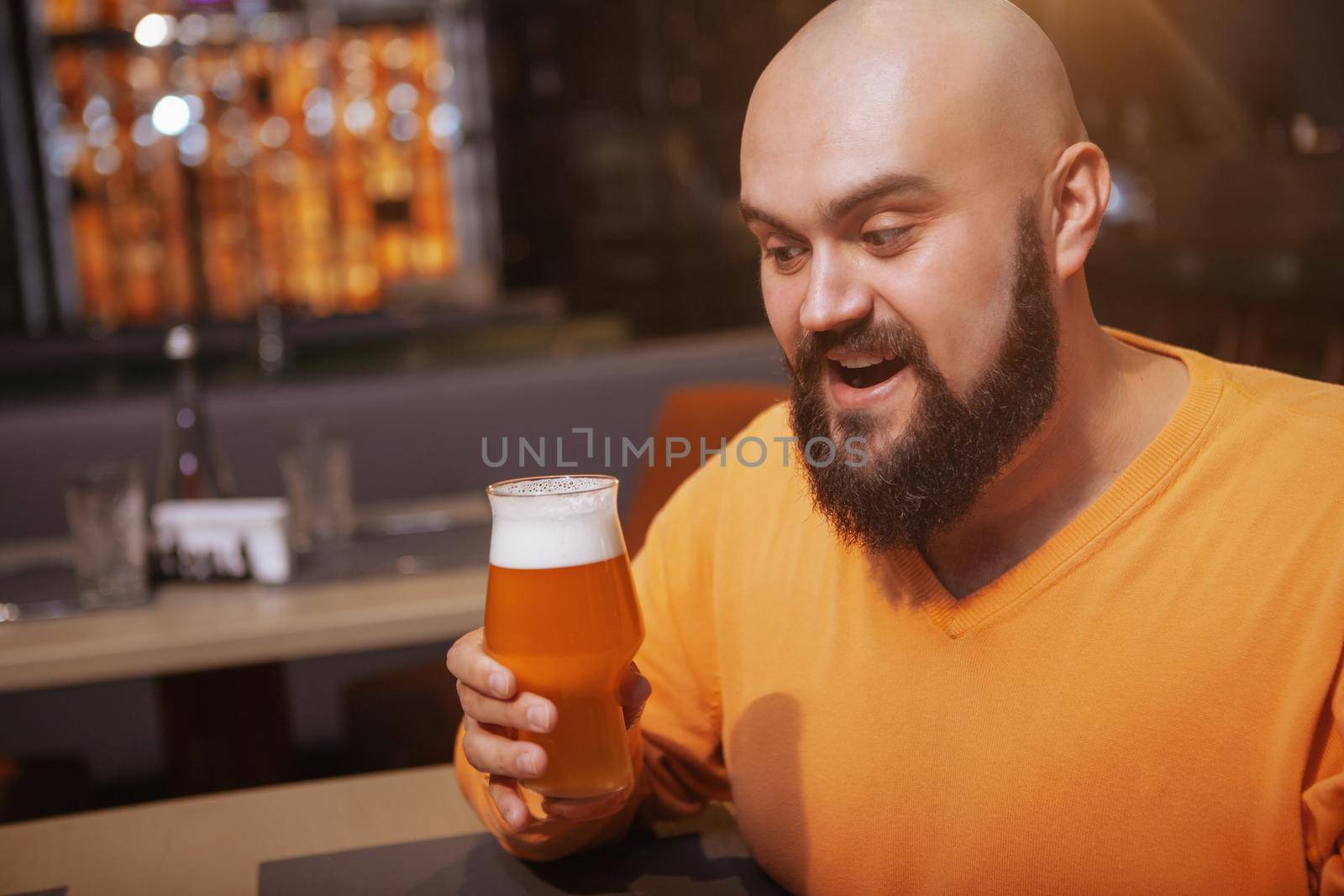 Excited man looking at his beer glass, copy space. Brewery, craft beer concept