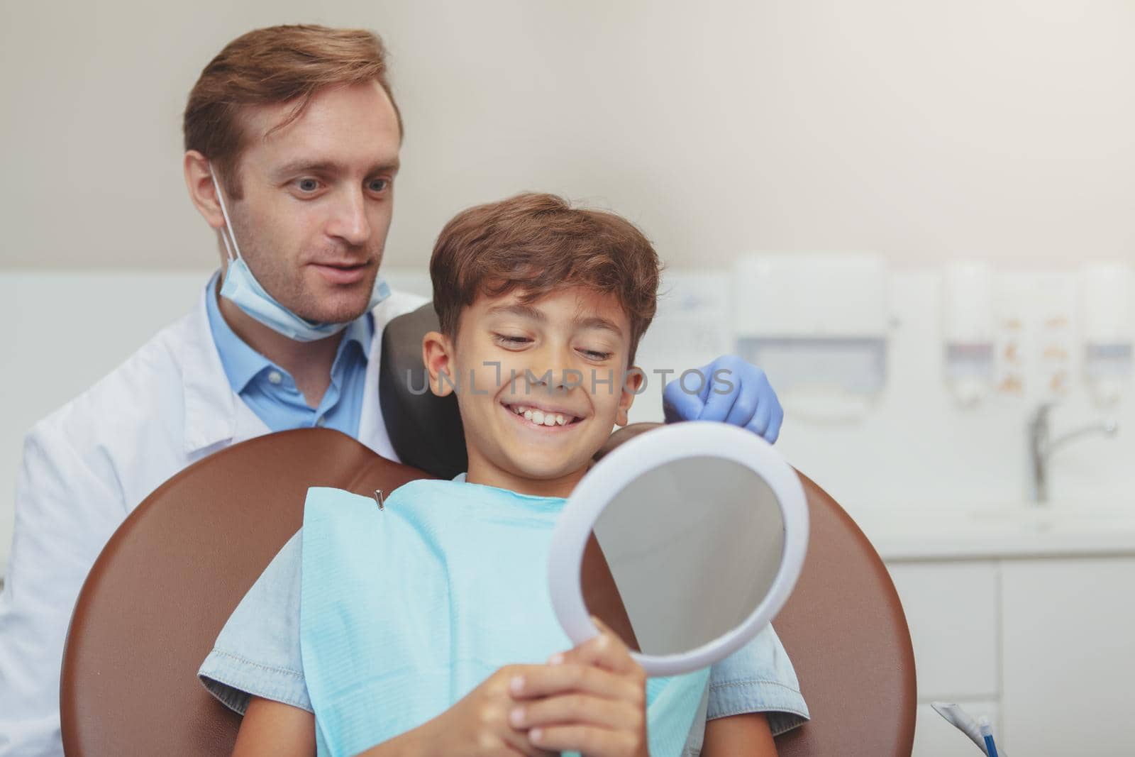 Happy healthy young boy at dental clinic by MAD_Production