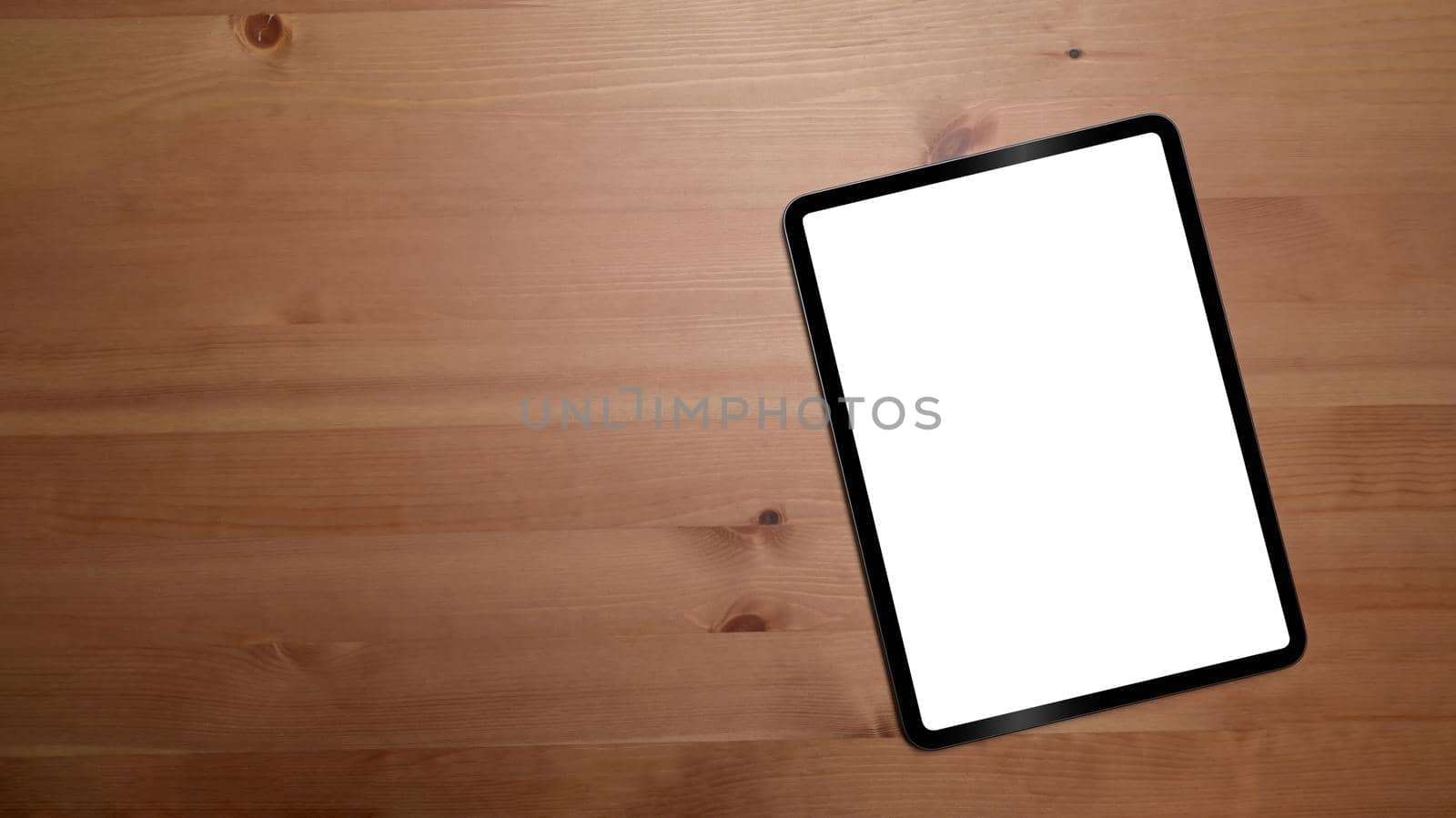 Mockup digital tablet with empty display on wooden background with copy space. by prathanchorruangsak