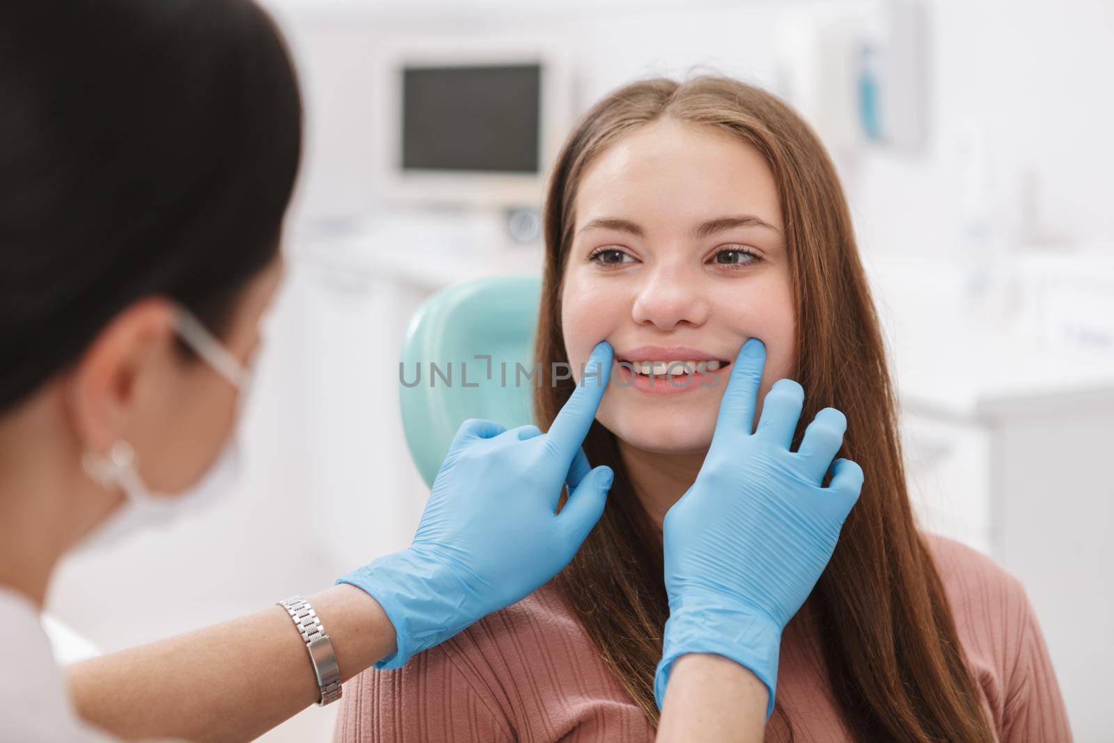 Lovely young woman getting dental checkup by professional dentist
