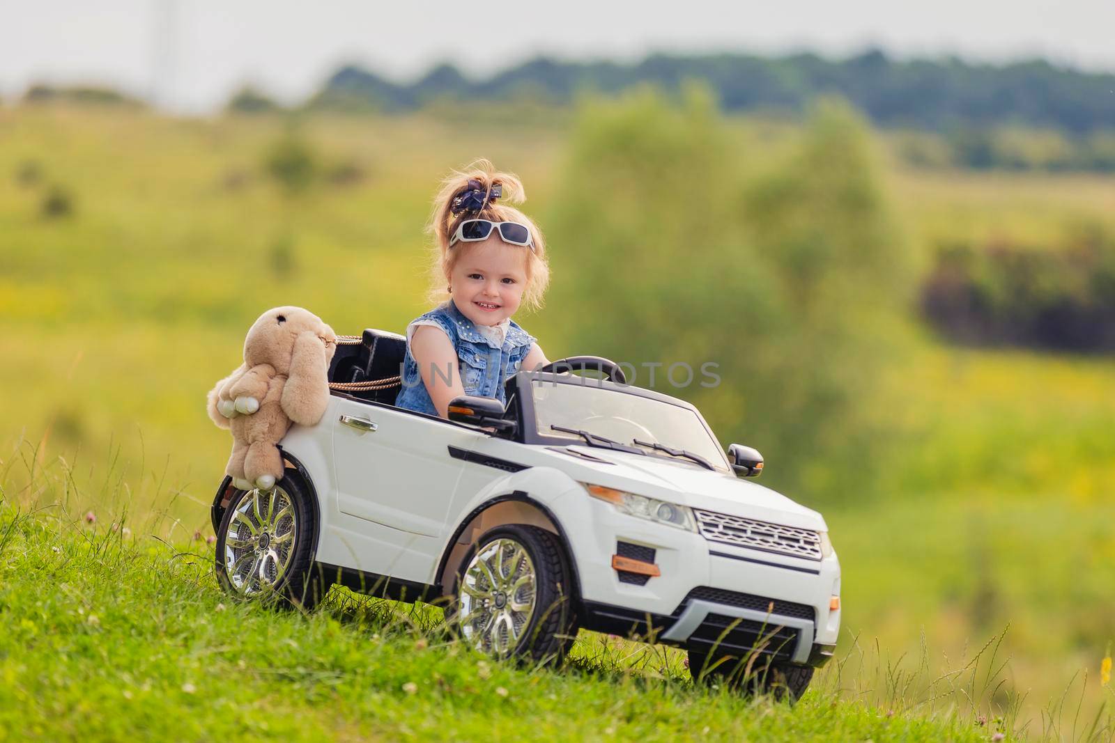 girl riding a white car on the lawn