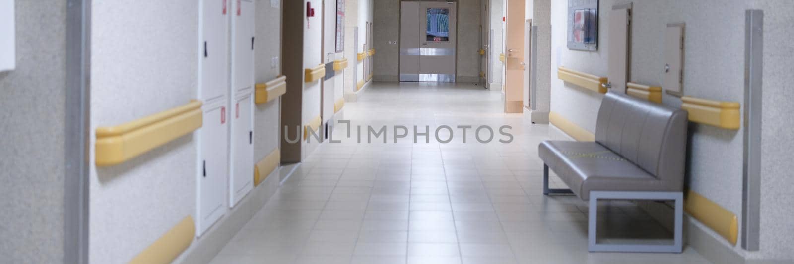 Contemporary empty building corridor, bright hall of the clinic. Clean room with a sofa for waiting, lobby. Floor interior