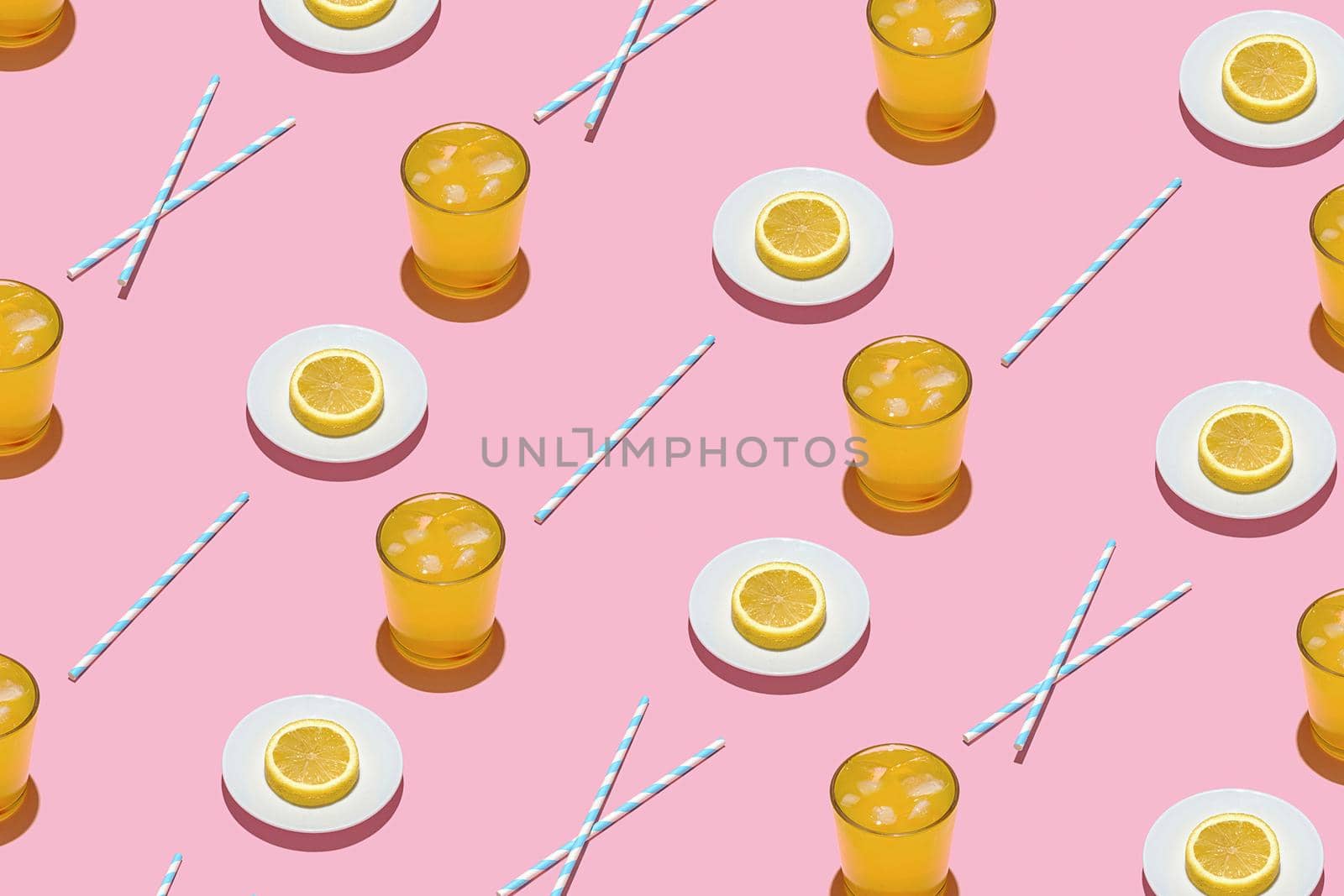 Summer pattern on a bright pink pastel background sunlight fruity orange cocktail plates and tubes. Minimal trend summer concept.