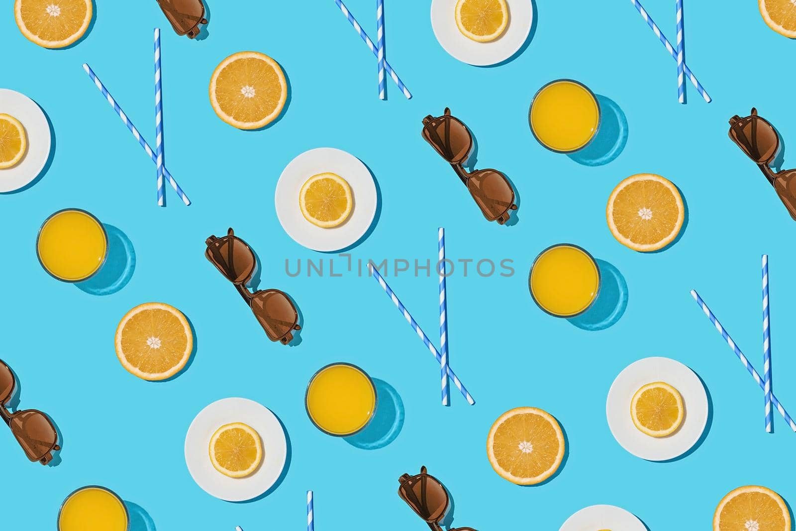 Summer pattern on a bright blue pastel background sunlight fruity orange and sunglasses. Minimal trend summer concept.