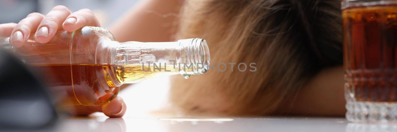 Upset drunk woman with a bottle of alcoholic beverage, close-up. Long-term alcohol dependence. Indecent behavior