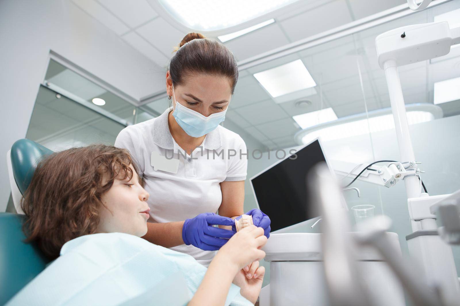 Dentist with her child patient by MAD_Production