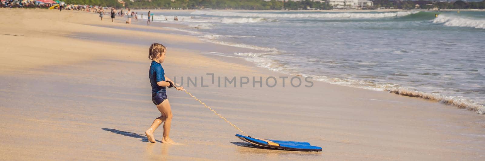 Happy Young boy having fun at the beach on vacation, with Boogie board. BANNER, LONG FORMAT