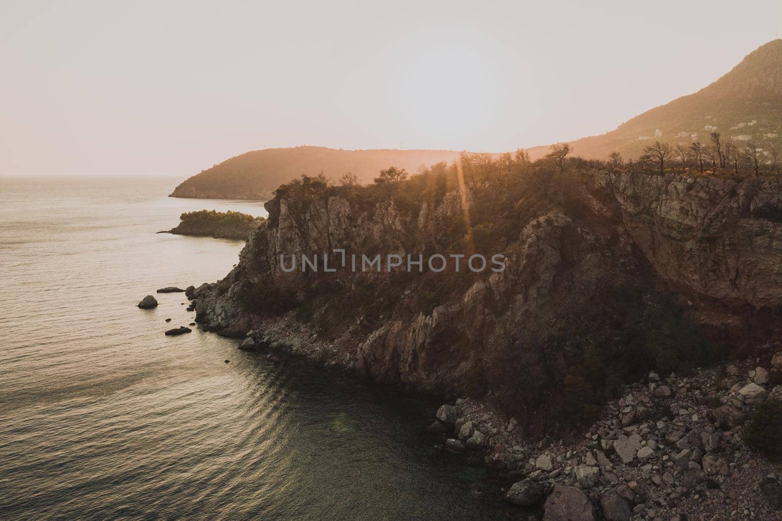 Aerial top evening view drone above Adriatic sea in Montenegro. panoramic sunny marine mountain sunset. summer nature wallpaper. dark calm water rock. mountains coast seaside. Amazing outdoors view