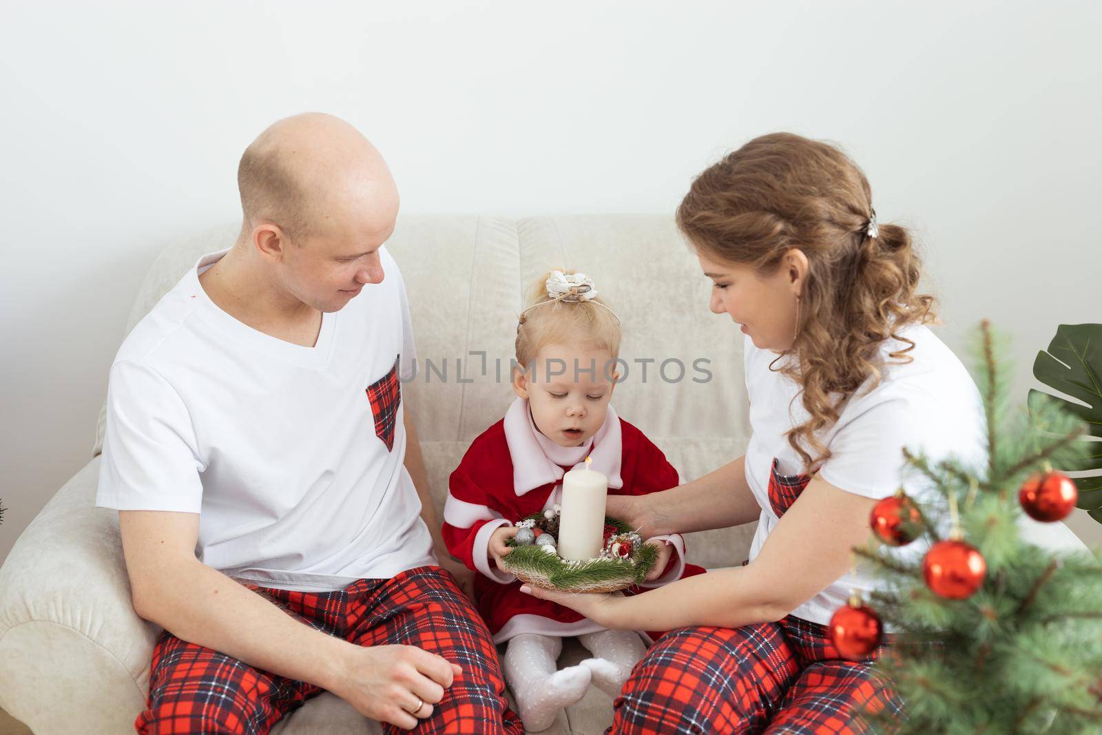 Child with cochlear implant hearing aid having fun with parents in christmas living room - diversity , deafness treatment and medical innovative technologies by Satura86