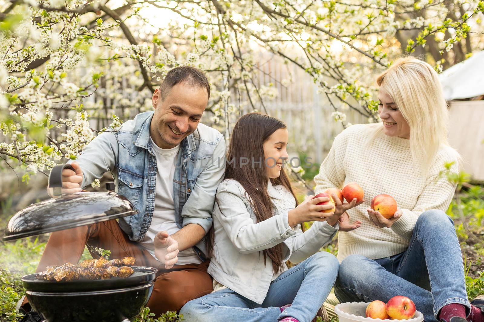 Family having a barbecue in their garden by Andelov13