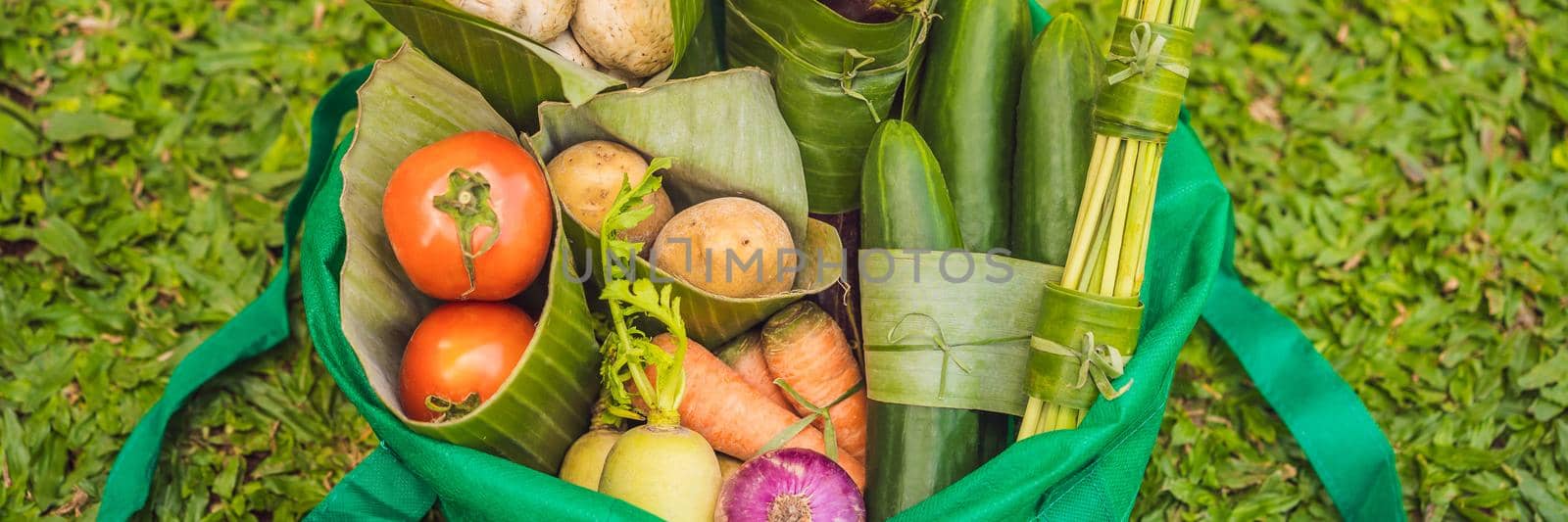 BANNER, LONG FORMAT Eco-friendly product packaging concept. Vegetables wrapped in a banana leaf, as an alternative to a plastic bag. Zero waste concept. Alternative packaging.