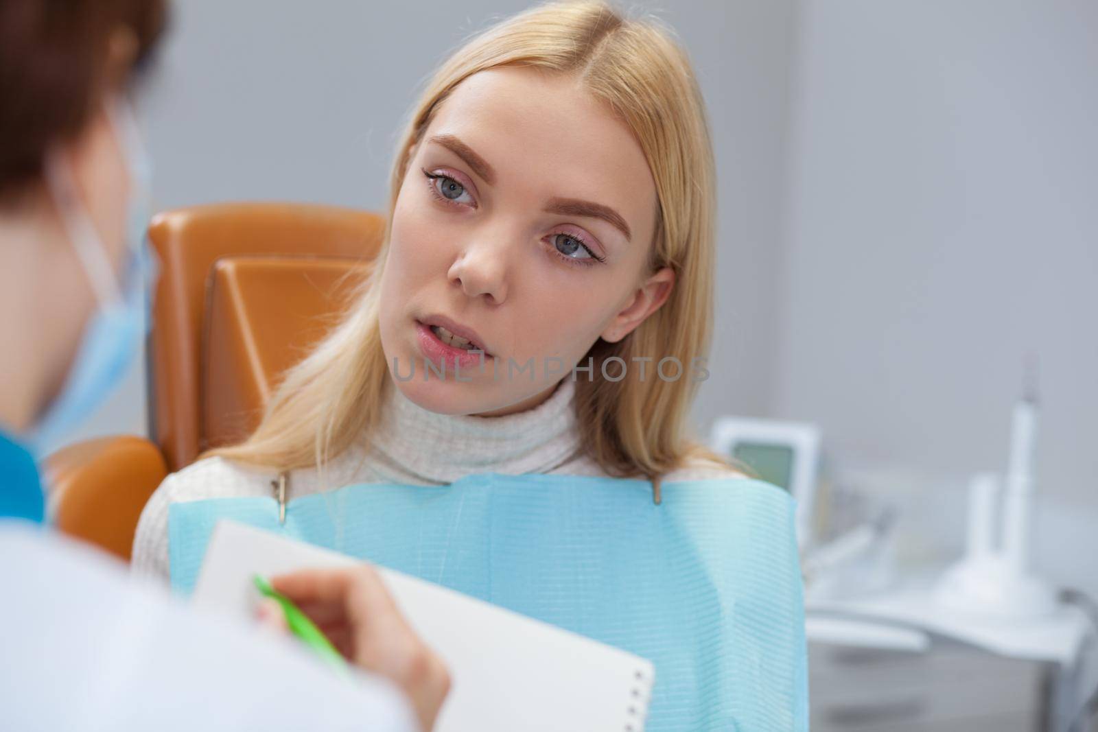 Female dentist working at her dental clinic by MAD_Production