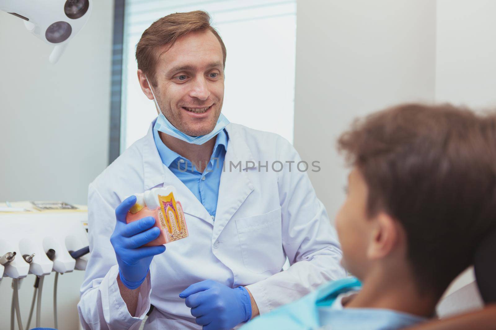 Professional dentist working with a patient by MAD_Production