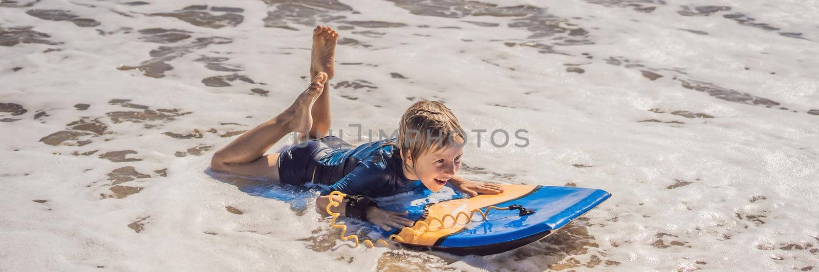 Happy Young boy having fun at the beach on vacation, with Boogie board BANNER, LONG FORMAT by galitskaya