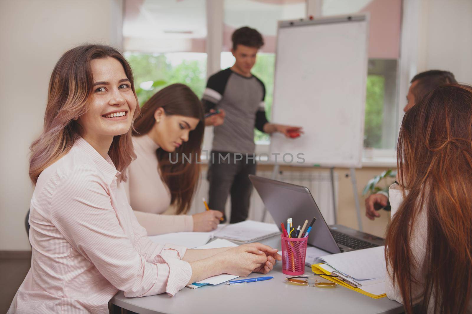 Group of young people studying together at college classroom by MAD_Production