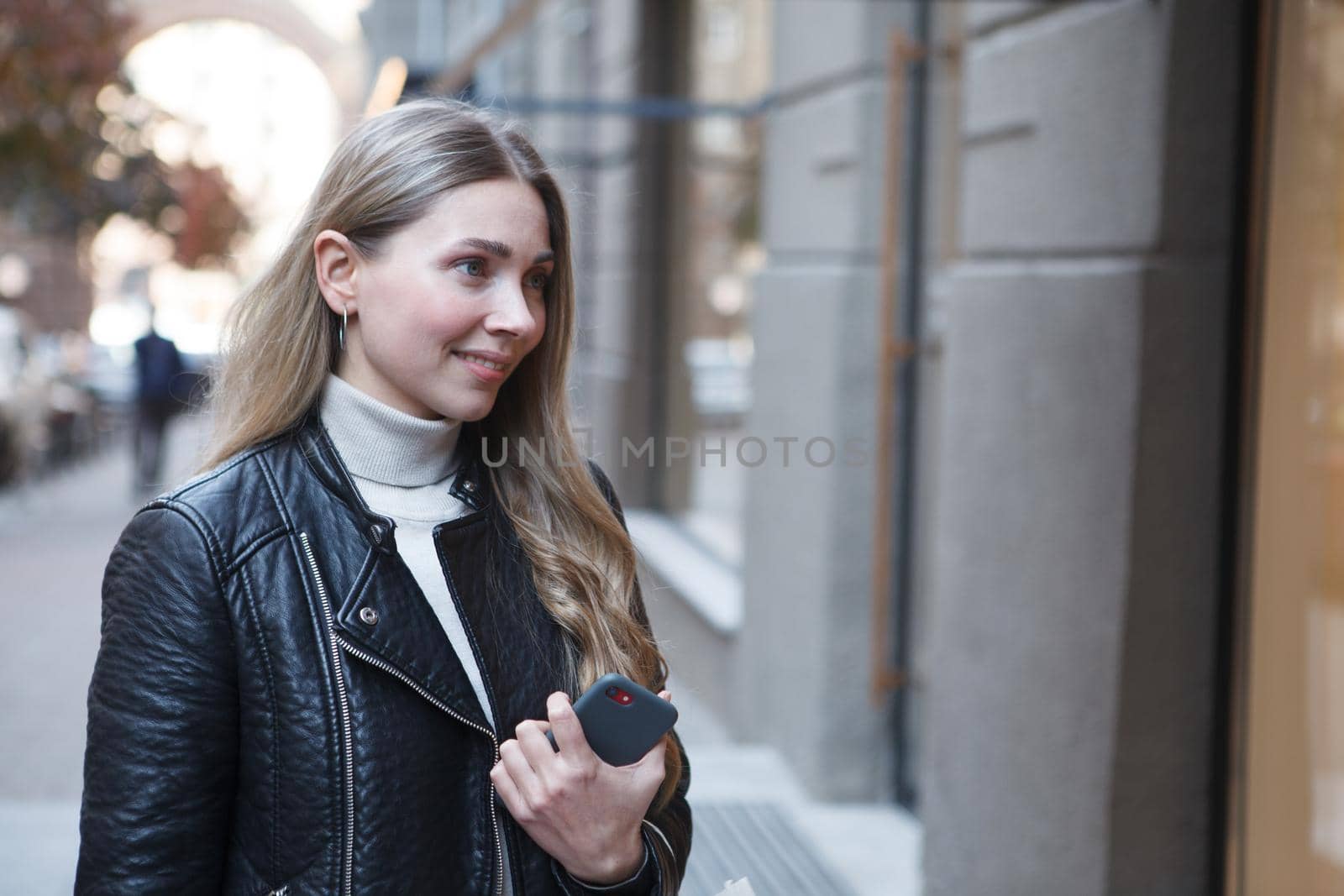 Attractive woman smiling while window shopping in city center