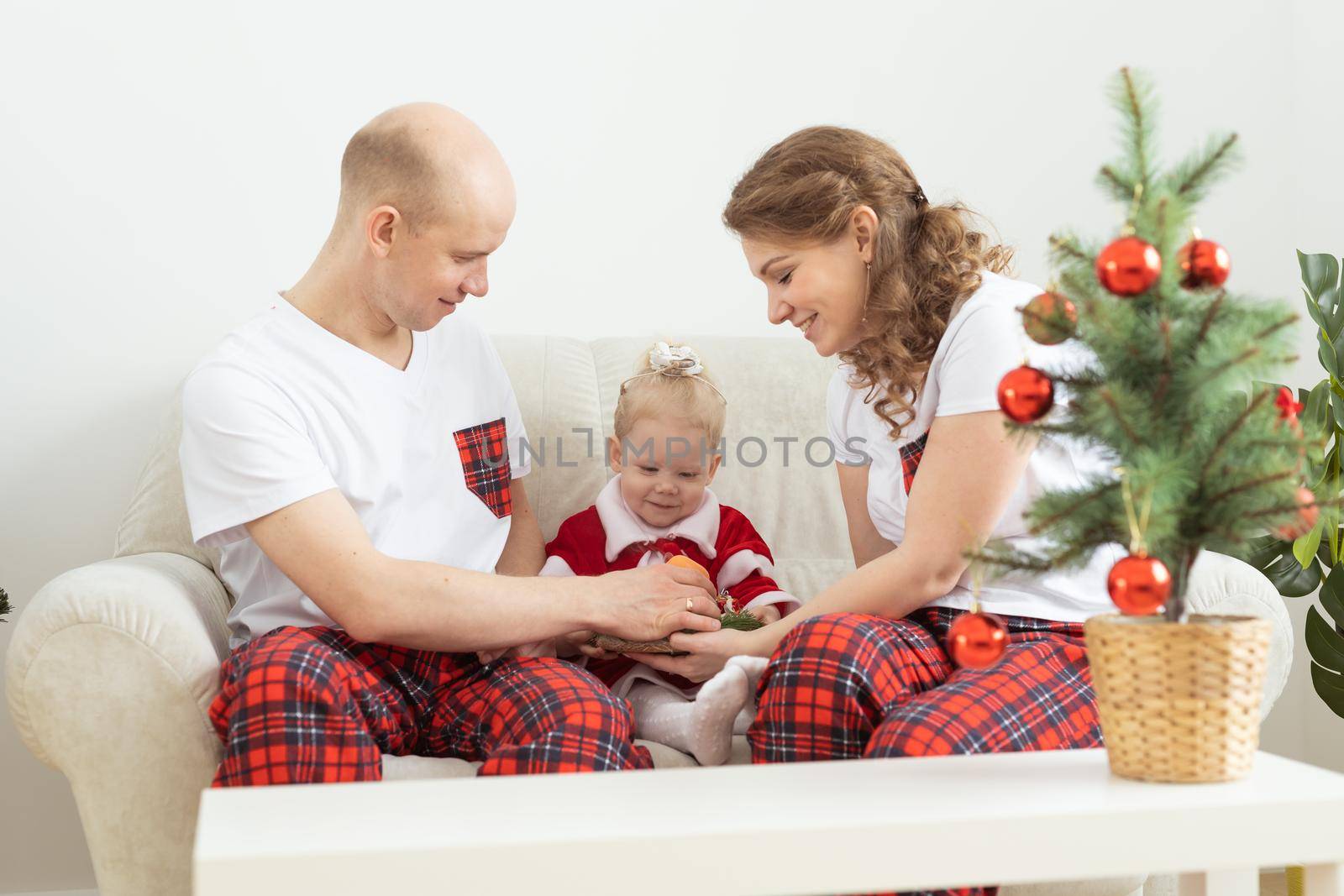 Child with cochlear implant hearing aid having fun with parents in christmas living room - diversity , deafness treatment and medical innovative technologies by Satura86