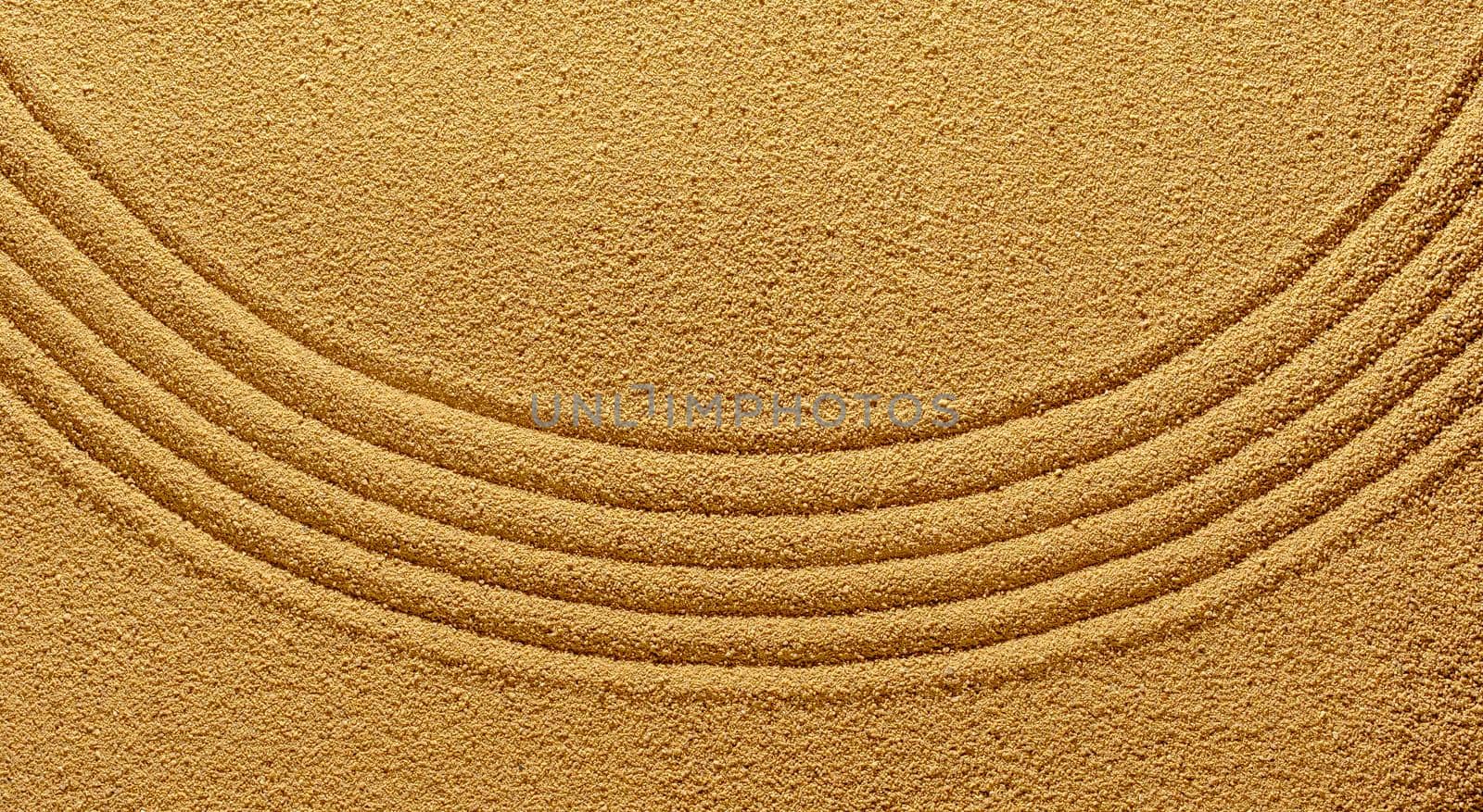 Background of yellow warm sand in summer with an abstract pattern of a smooth line of the arc for the harmony of the spirit.
