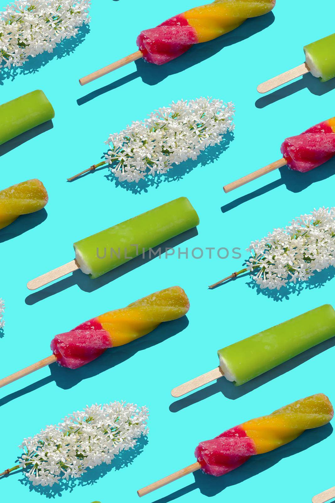 Bright pastel summer pattern ice cream and flowers in a flat lay style and top view. Minimal creative summer food and joy concept.