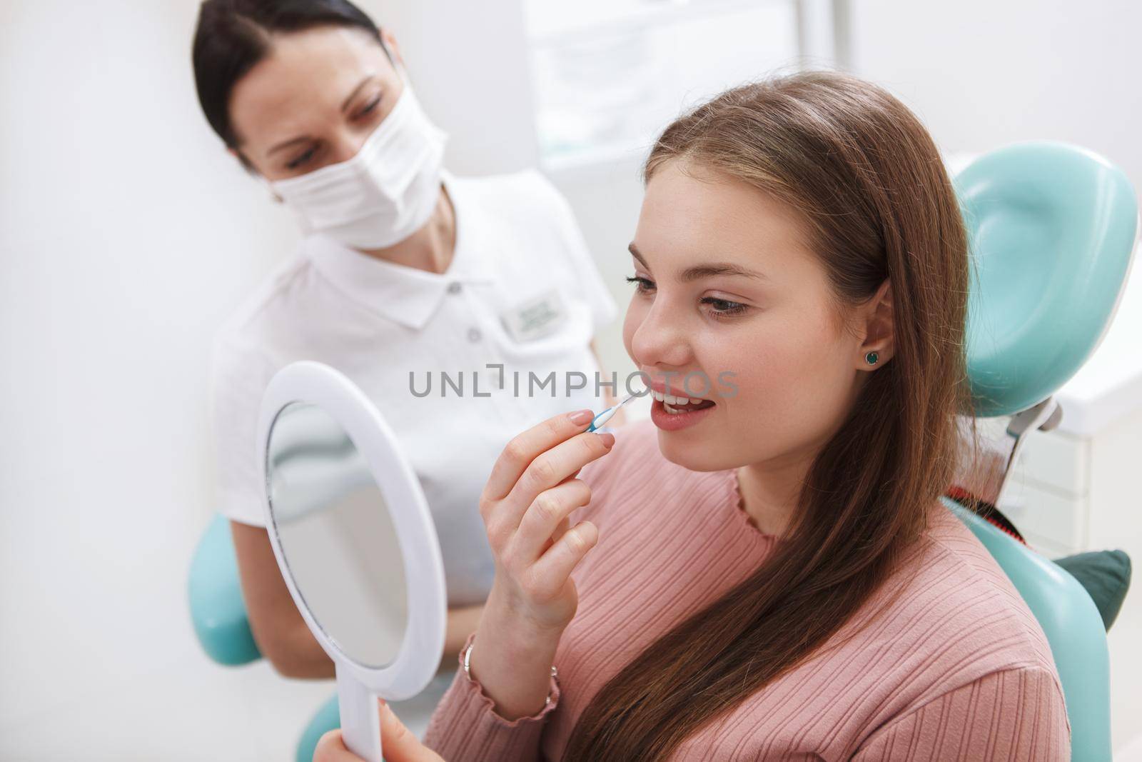 Young woman learning using interdental toothbrush at dentists office