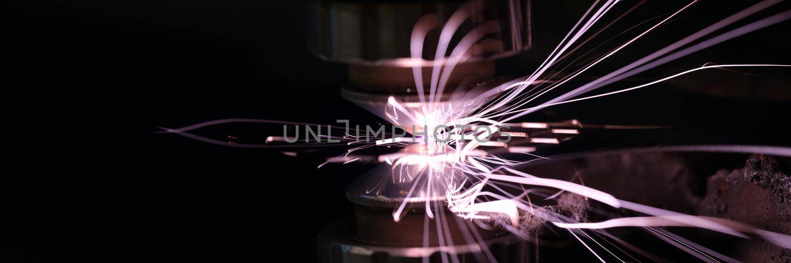 Sparks from metal on a dark background, close-up of the machine tool. Design element, production of steel parts
