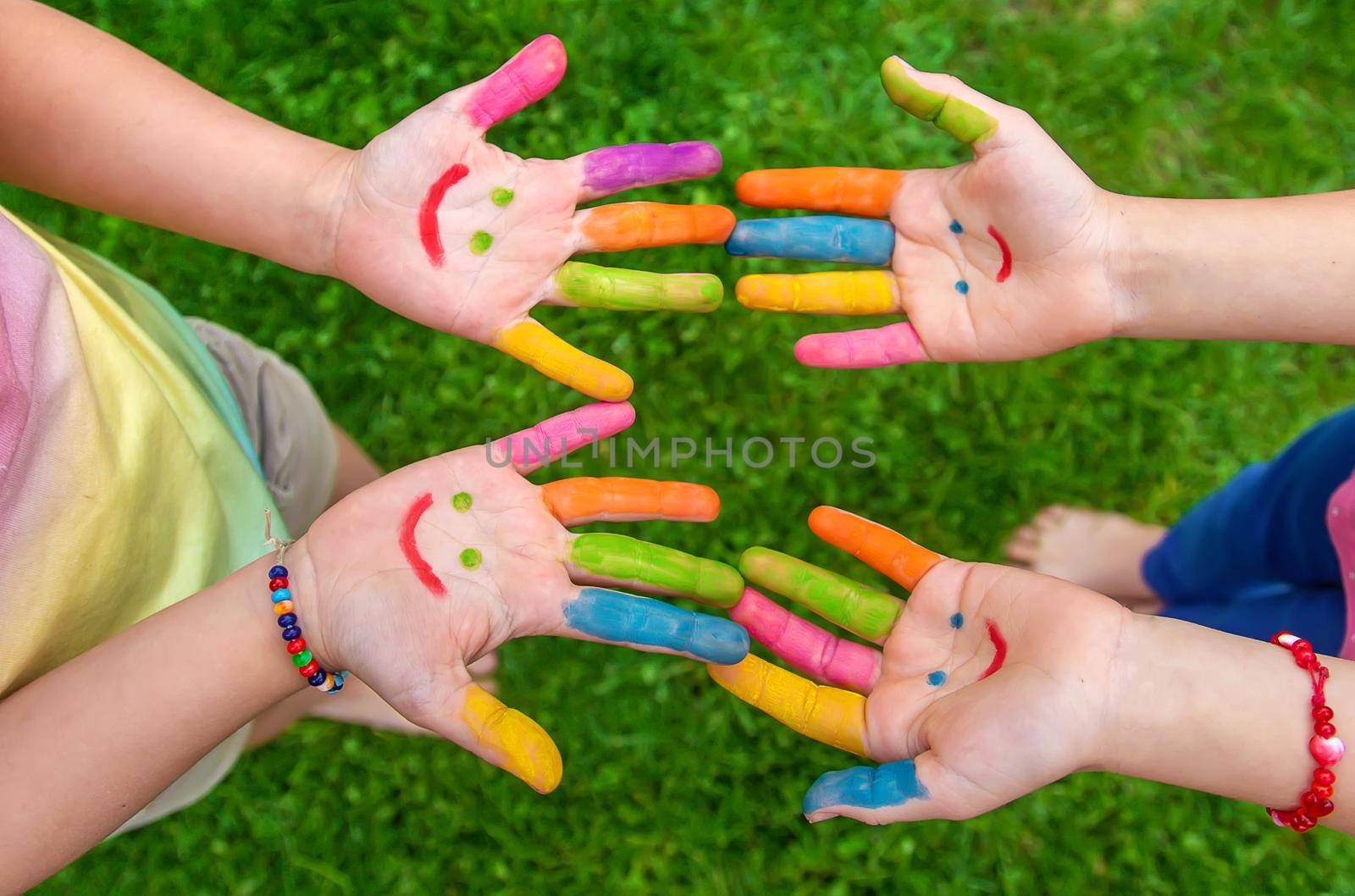 Hands of a child with a drawn emoticon. Selective focus.