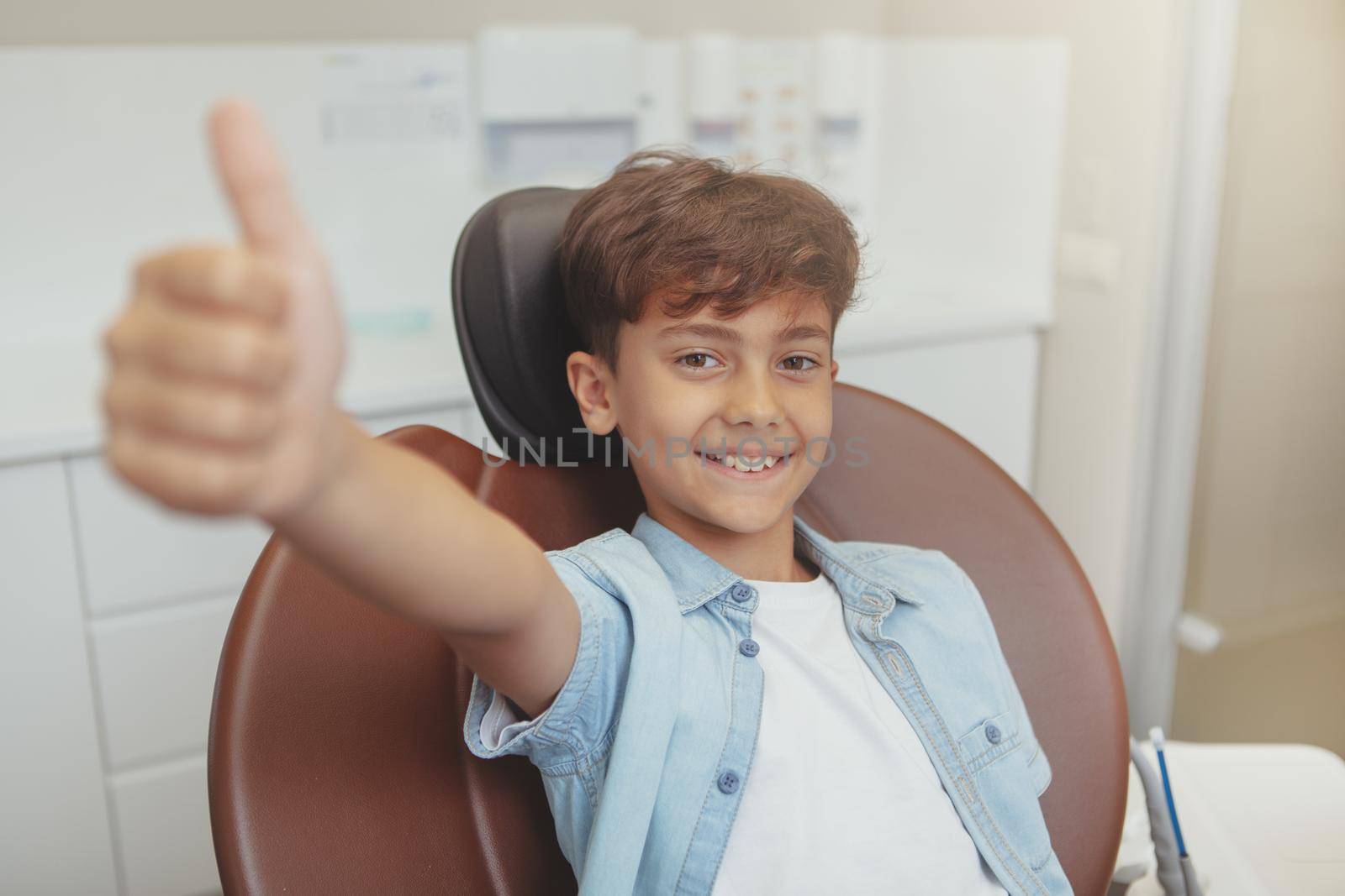 Happy healthy young boy at dental clinic by MAD_Production
