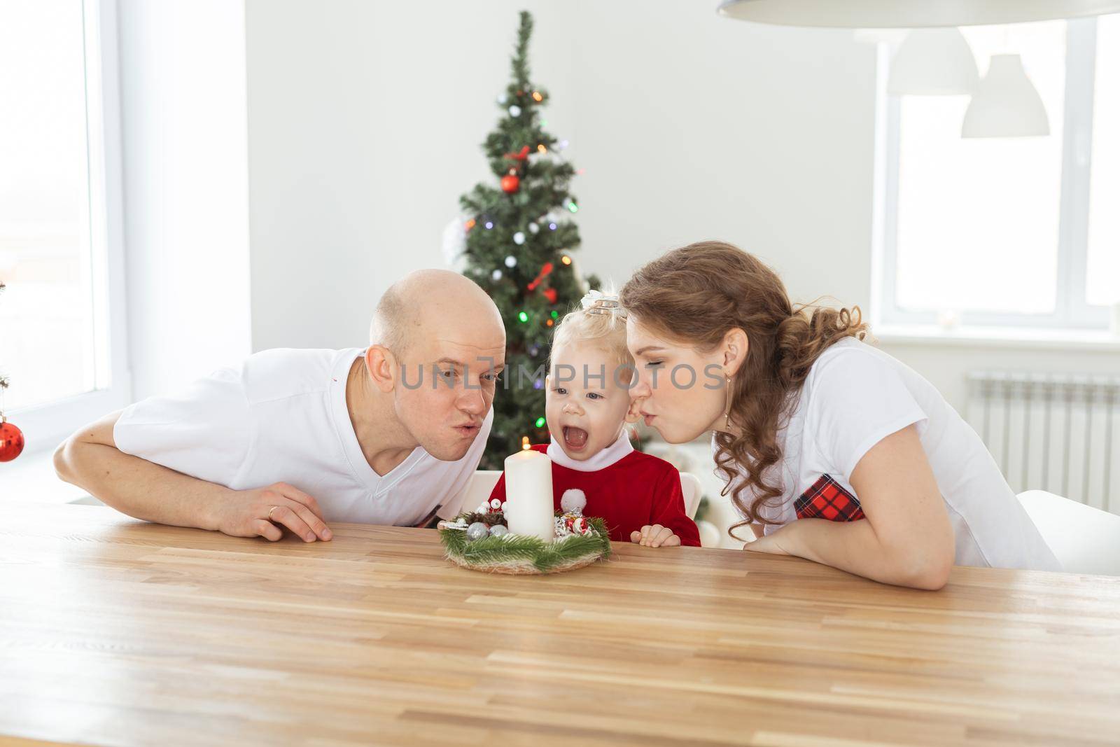 Baby child with hearing aid and cochlear implant having fun with parents in christmas room. Deaf and health