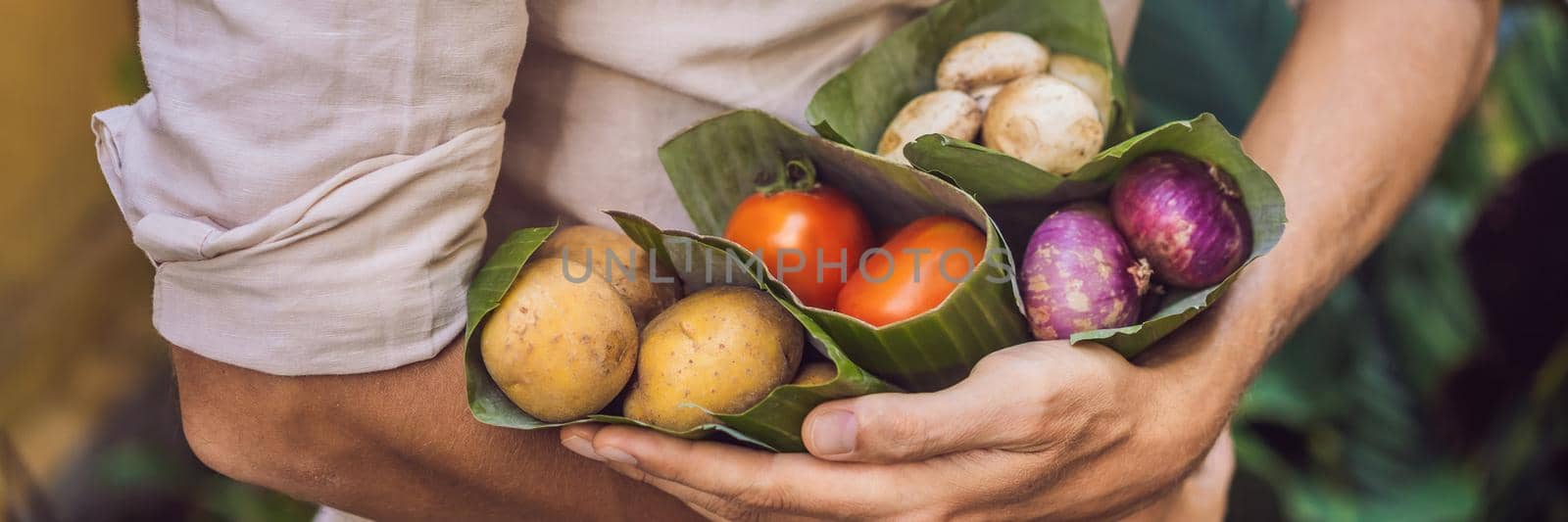 BANNER, LONG FORMAT Eco-friendly product packaging concept. Vegetables wrapped in a banana leaf, as an alternative to a plastic bag. Zero waste concept. Alternative packaging by galitskaya