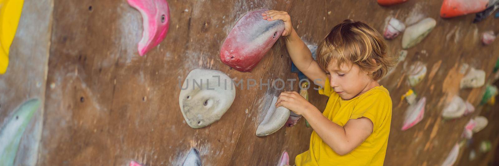 little boy climbing a rock wall in special boots. indoor. BANNER, LONG FORMAT