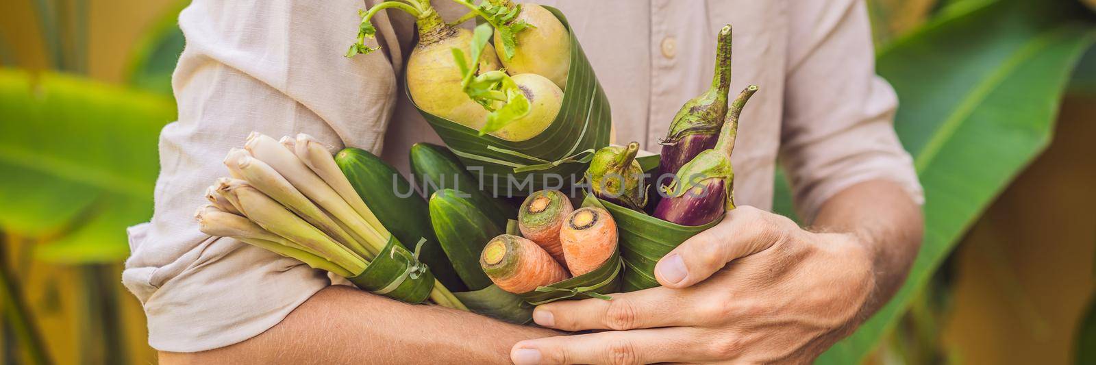 BANNER, LONG FORMAT Eco-friendly product packaging concept. Vegetables wrapped in a banana leaf, as an alternative to a plastic bag. Zero waste concept. Alternative packaging by galitskaya