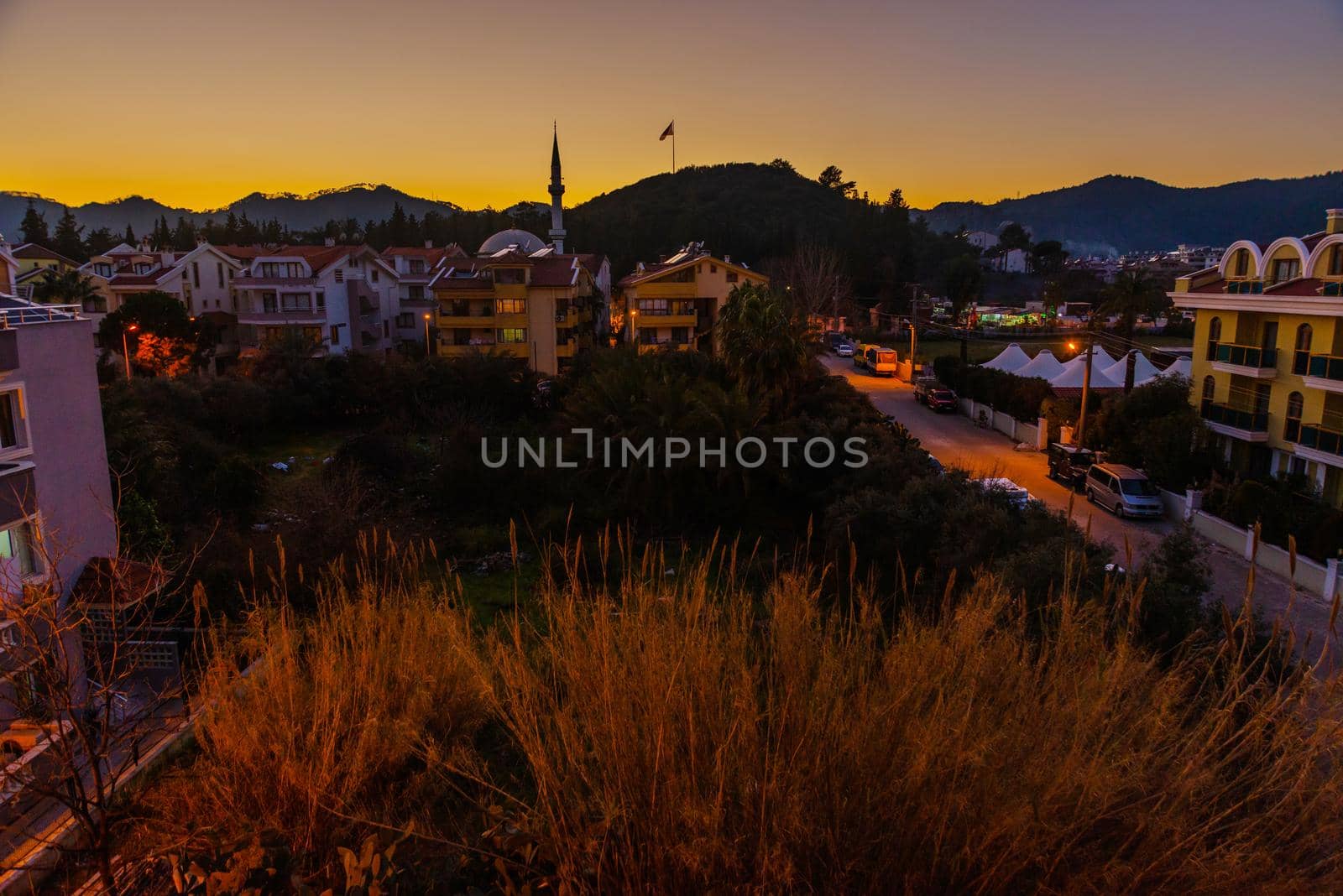 MARMARIS, MUGLA, TURKEY: Evening landscape with a view of hotels, residential buildings and a mosque in Marmaris at sunset.