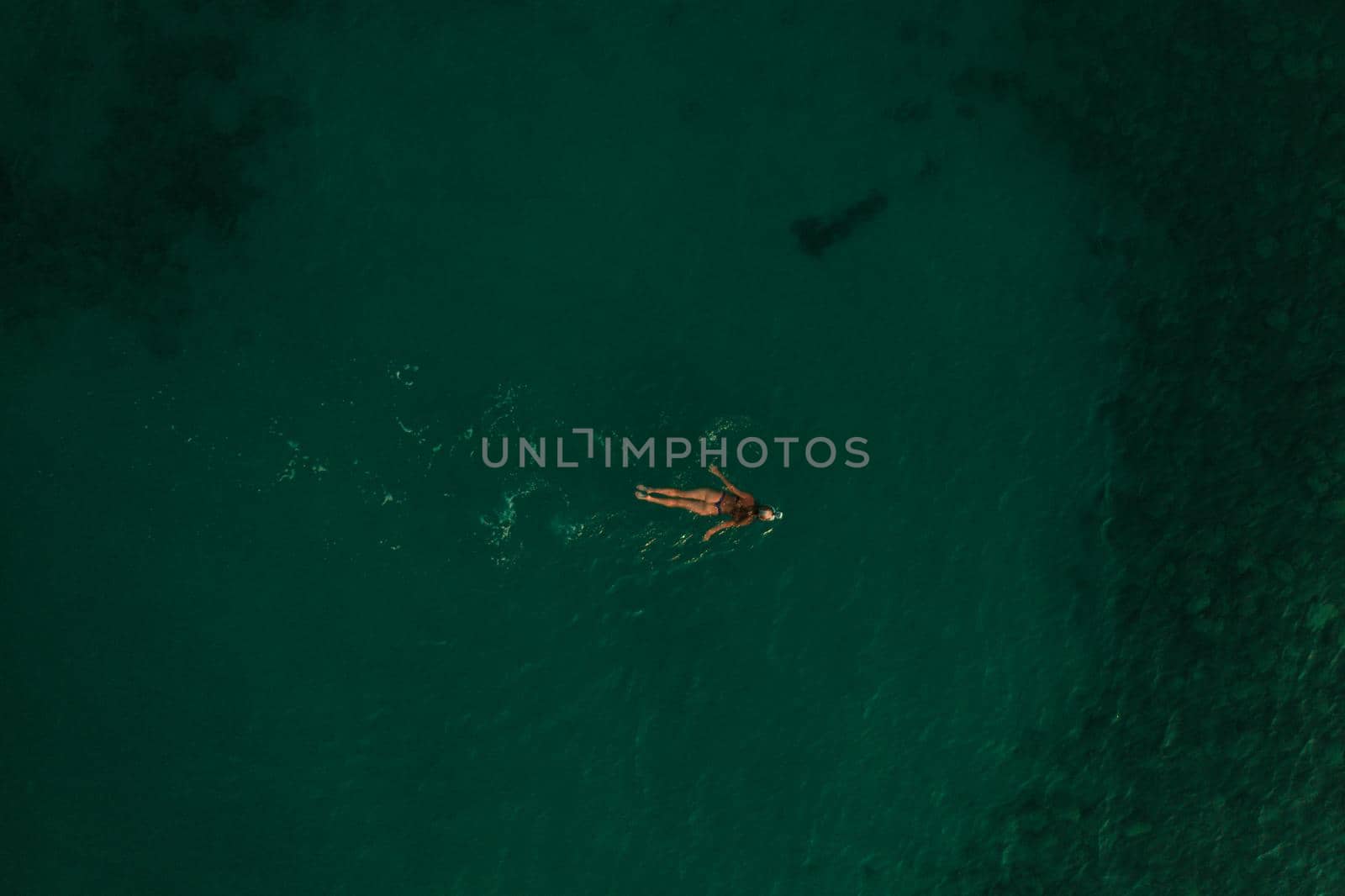 Aerial top nature view above green turquoise Thracian sea Greece Ellada. Beautiful woman bikini by AndriiDrachuk