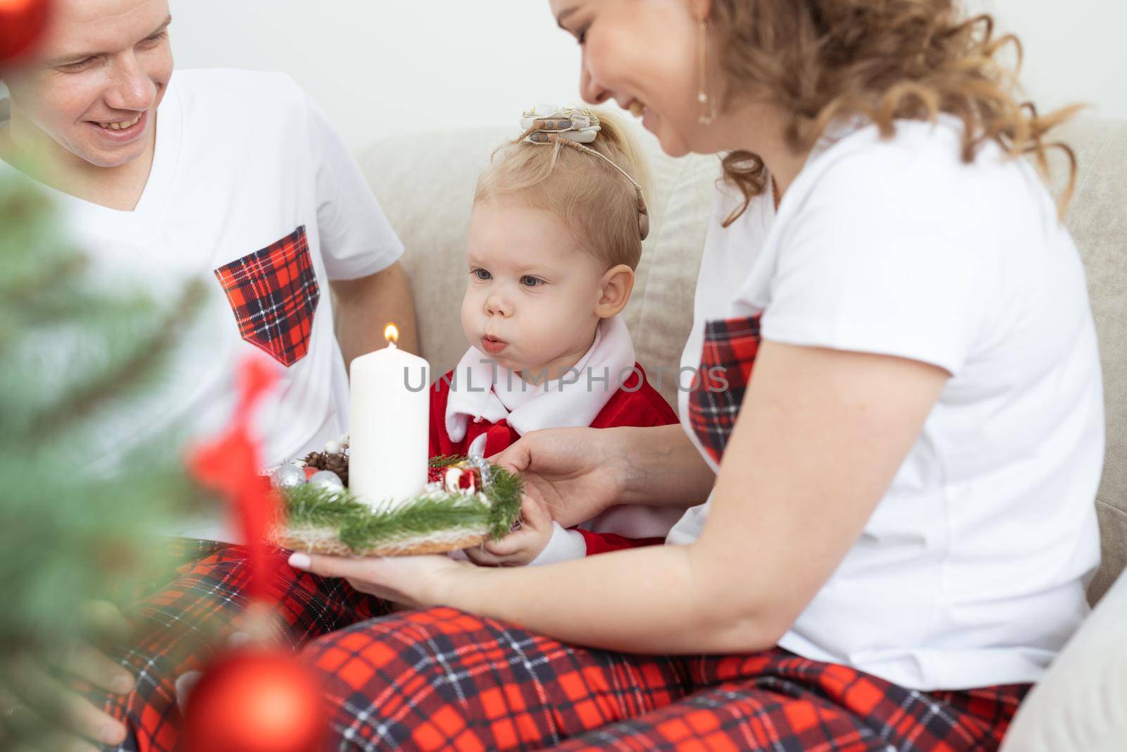 Baby child with hearing aid and cochlear implant having fun with parents in christmas room. Deaf , diversity and health concept by Satura86