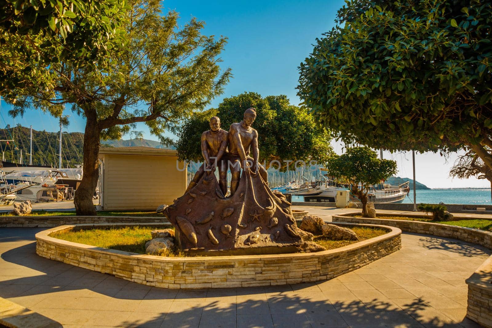 MARMARIS, MUGLA, TURKEY: MARMARIS, TURKEY: A monument to two fishermen with nets on the embankment near the port of Marmaris.