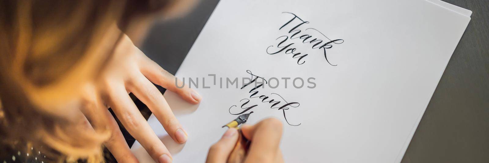 BANNER, LONG FORMAT Thank you. Calligrapher Young Woman writes phrase on white paper. Inscribing ornamental decorated letters. Calligraphy, graphic design, lettering, handwriting, creation concept by galitskaya